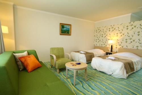 une chambre d'hôtel avec deux lits et un canapé dans l'établissement Hotel Shiretoko, à Shari