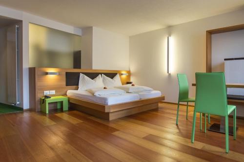 a bedroom with a bed and a table and chairs at Hotel Al Cervo in Tesero
