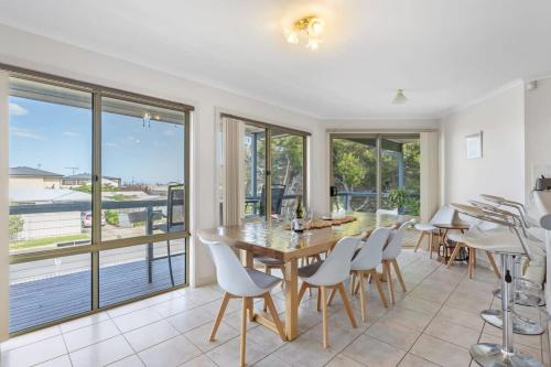 Goolwa Southにある69 Shepherd Ave Goolwa South - BYO Linenのテーブルと椅子と窓のあるダイニングルーム
