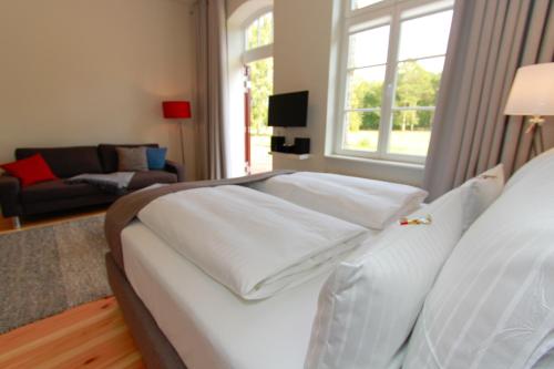 a bedroom with a large white bed and a living room at Ferienwohnungen Bahnhof Werder in Jüterbog