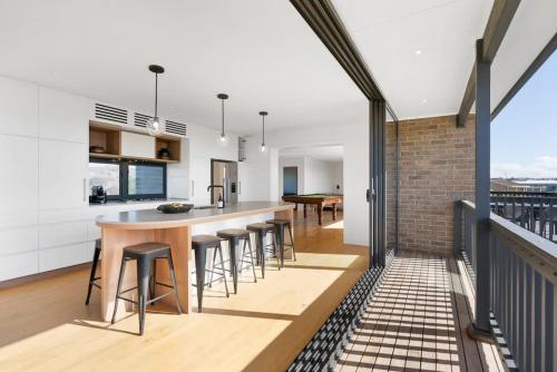 a kitchen and dining room with a bar on the balcony at 81 Bristow-Smith Ave Goolwa Beach - BYO Linen - WiFi in Goolwa South