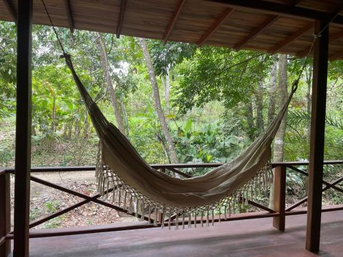 a hammock on a porch in a forest at El Retiro De Carolina in Santa Marta