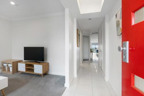 a living room with a television and a red door at Hindmarsh Island Marina Lifestyle - BYO Linen in Hindmarsh Island