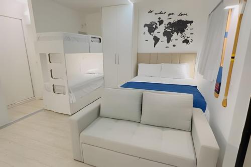 a small room with a white couch and a bed at Luxuoso flat familiar beira lago in Brasilia