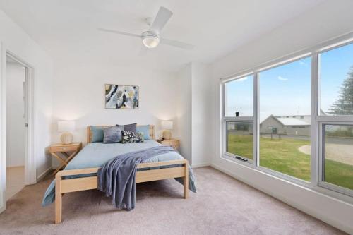 um quarto com uma cama e janelas grandes em 72 Seagull Ave Chiton - BYO Linen em Hayborough
