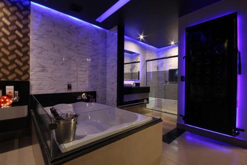 a large bathroom with a large tub with purple lights at Motel Deslize Limeira 5 in Limeira