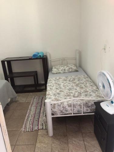 a small bedroom with a bed and a desk at Hostel Dourado in Barra do Garças