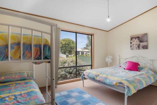 a bedroom with two beds and a large window at Cave Street Retreat - 38 Cave Street Goolwa Beach - BYO Linen in Goolwa South