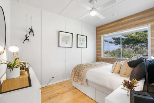 ein weißes Schlafzimmer mit einem Bett und einem Fenster in der Unterkunft On Birchall - Main House and Bunk House - BYO Linen in Goolwa