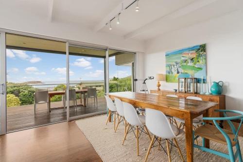 a dining room with a wooden table and chairs at 10 Passatt St Encounter Bay - BYO Linen in Encounter Bay
