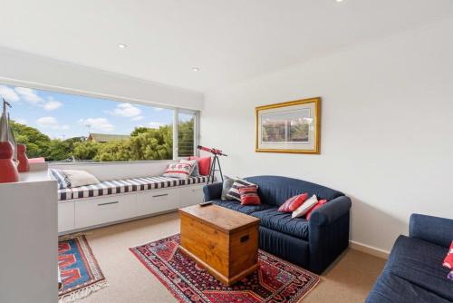 a living room with a blue couch and a window at 10 Passatt St Encounter Bay - BYO Linen in Encounter Bay