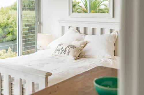a white bed with pillows in a room with a window at 10 Passatt St Encounter Bay - BYO Linen in Encounter Bay