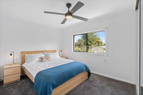Un dormitorio con una cama con ventilador de techo. en 1 Bowley Street Goolwa Beach - BYO Linen, en Goolwa South