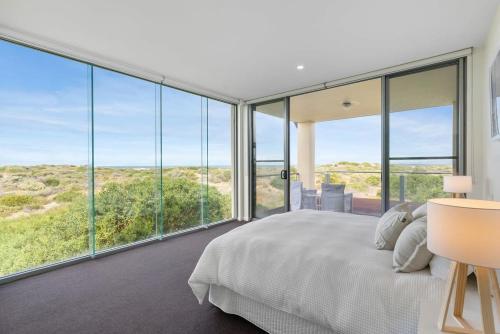 ein Schlafzimmer mit einem großen Bett und großen Glasfenstern in der Unterkunft Samphire Middleton-Beach - BYO Linen - Wi-Fi-Luxury-Family in Middleton