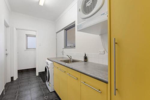 eine Küche mit einer Spüle und einer Waschmaschine in der Unterkunft Samphire Middleton-Beach - BYO Linen - Wi-Fi-Luxury-Family in Middleton