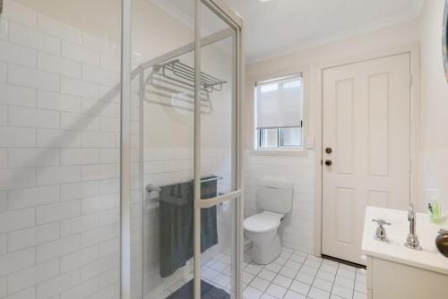 a bathroom with a toilet and a glass shower at Beladura - 35 Goolwa Channel Drive Hindmarsh Island - Linen Included in Hindmarsh Island