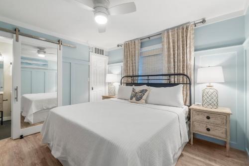 una camera da letto con un letto bianco e uno specchio di Beachside Villas #312 a Santa Rosa Beach