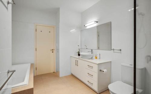 La salle de bains est pourvue d'un lavabo, de toilettes et d'un miroir. dans l'établissement 4A Franklin Pde Encounter Bay - BYO Linen, à Victor Harbor