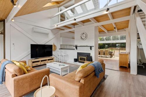 a living room with two couches and a fireplace at The Glass House 103 Bristow-Smith Ave Goolwa South - BYO Linen in Goolwa South