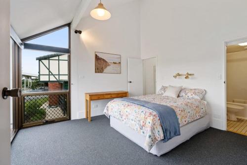 a bedroom with a bed and a sliding glass door at The Glass House 103 Bristow-Smith Ave Goolwa South - BYO Linen in Goolwa South