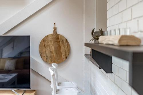 a room with a tv and a plate on a wall at The Glass House 103 Bristow-Smith Ave Goolwa South - BYO Linen in Goolwa South