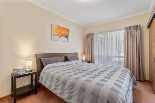 a bedroom with a large bed and a window at 4 1 Harbour View Terrace BYO Linen in Victor Harbor