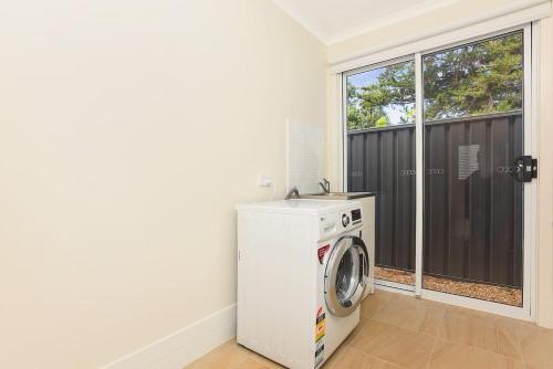 a washing machine in a room with a window at 24A Petrel Ave - Wi-Fi - No Linen Included in Encounter Bay