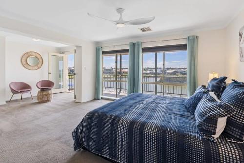 a bedroom with a blue bed and a balcony at T2 12 Wentworth Pde Hindmarsh Island - No Linen Included in Hindmarsh Island