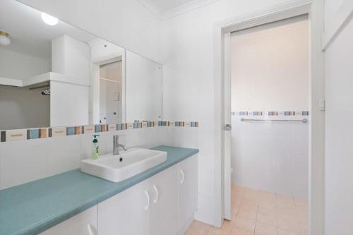 a white bathroom with a sink and a mirror at T2 12 Wentworth Pde Hindmarsh Island - No Linen Included in Hindmarsh Island