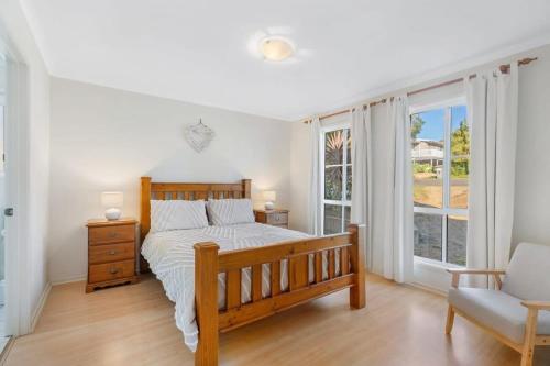a bedroom with a bed and a chair and windows at BONAVIVE Port Elliot - Luxury - Family - Township - No Linen Included in Port Elliot