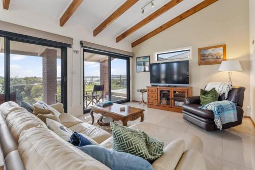 a living room with a couch and a tv at 20 Sir George Ritchie Ave Goolwa South - No Linen Included in Goolwa South