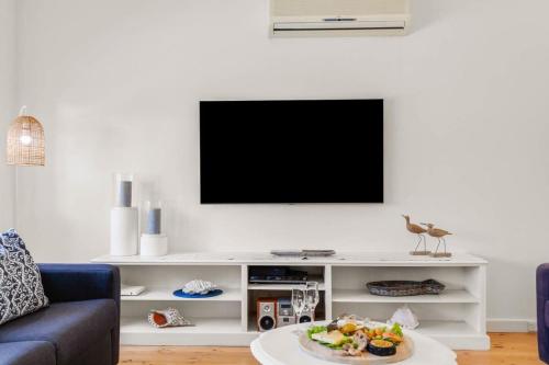 ポート・エリオットにある18 Strangways Tce Port Elliot - Linen Includedのリビングルーム(白いエンターテイメントセンター内のテレビ付)