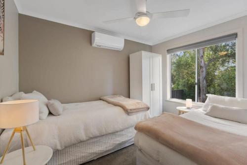 Un dormitorio blanco con dos camas y una ventana. en Hidden Little Gem - Township - Luxury - Linen Included, en Middleton