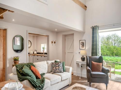 a living room with a couch and a chair at The Hay Loft - Uk45607 in Sigglesthorne