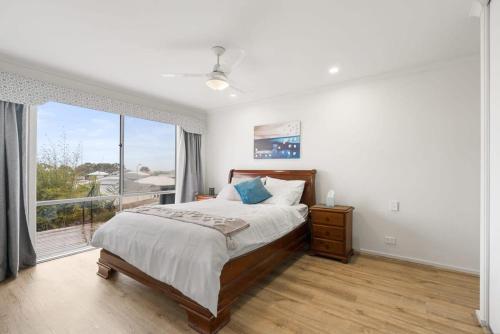 a bedroom with a bed and a large window at Serendipity - 27 Shields Crs Encounter Bay - No Linen Included in Encounter Bay