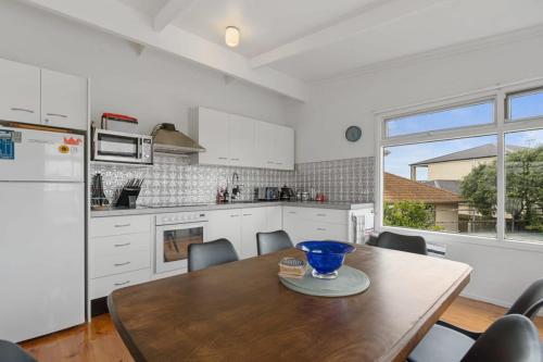 a kitchen with a wooden table with chairs and a refrigerator at Tee and Tide Retreat - Linen Included in Goolwa South