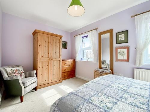1 dormitorio con 1 cama y 1 silla en St, Andrews Mews en Wells
