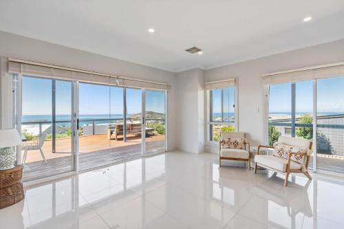 a white living room with a view of the ocean at 3 Jill Ct Encounter Bay in Encounter Bay