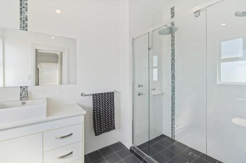 uma casa de banho branca com um chuveiro e um lavatório. em 3 Jill Ct Encounter Bay em Encounter Bay