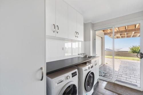 a white laundry room with a washer and dryer at 3 Jill Ct Encounter Bay in Encounter Bay