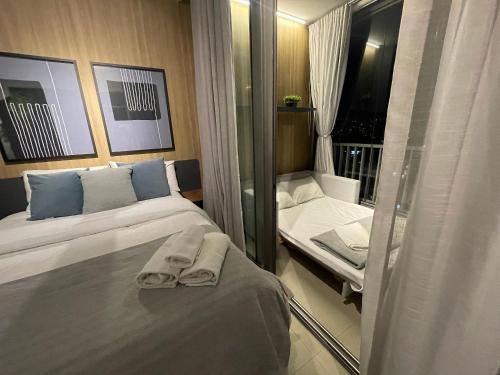 a hotel room with two beds and a mirror at Apartamentos em frente ao Allianz Parque in Sao Paulo