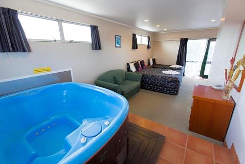 sala de estar con bañera en el centro de una habitación en Gateway International Motel, en Rotorua