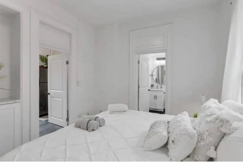 a white bedroom with a large white bed with pillows at Housepitality - The Short North Sanctuary in Columbus