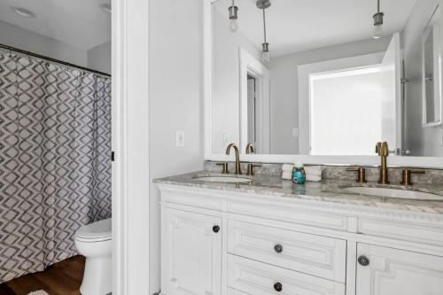 a bathroom with two sinks and a toilet at Housepitality - The Capital House - 5 BR Downtown in Columbus