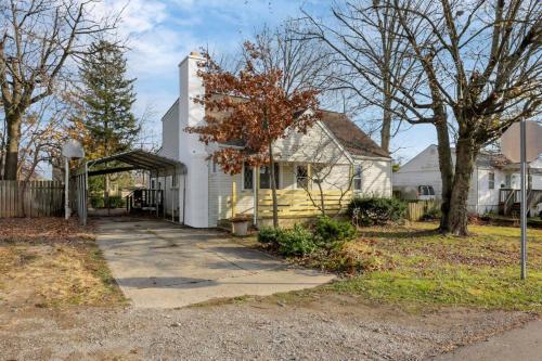 a white house with a porch and a fence at Housepitality - West Side Lodge - 6 BR 2 BA in Columbus