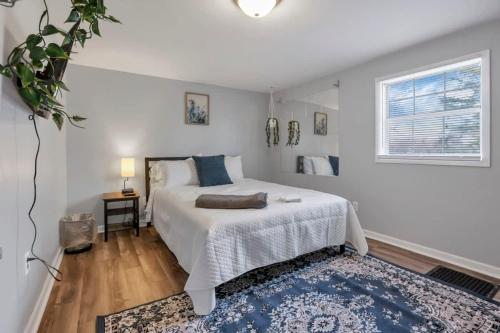 1 dormitorio con cama blanca y alfombra azul en Housepitality - West Side Lodge - 6 BR 2 BA, en Columbus