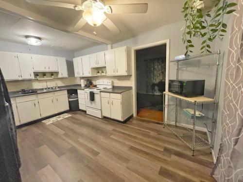 a kitchen with white cabinets and a hard wood floor at Housepitality - West Side Lodge - 6 BR 2 BA in Columbus