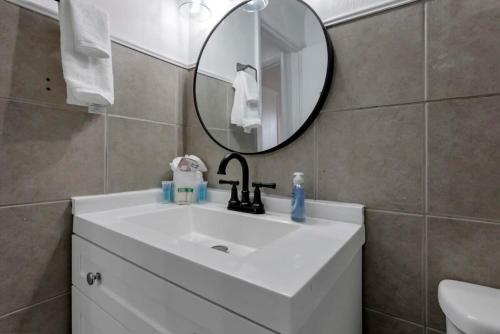 a bathroom with a white sink and a mirror at Housepitality - West Side Lodge - 6 BR 2 BA in Columbus