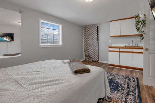 a white bedroom with a bed and a sink at Housepitality - West Side Lodge - 6 BR 2 BA in Columbus