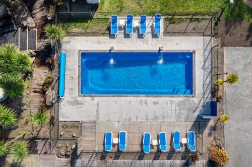 una vista aérea de una piscina con 4 sillas azules en Tasman Holiday Parks - Rotorua en Rotorua
